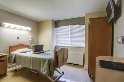 A private resident room with a bed and workstation