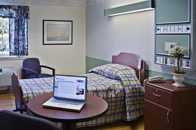 Comfortable resident room with bed and furniture