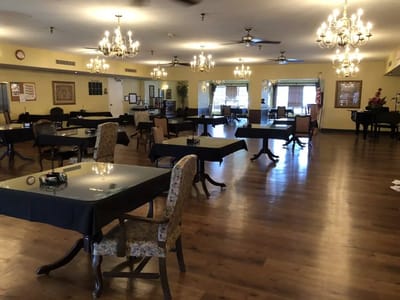 Dining area with tables and chandeliers in a senior living facility