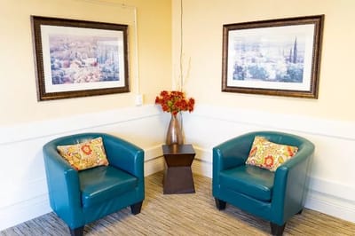 Cozy seating area with blue chairs and artwork