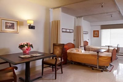 Interior view of a resident room with beds and a table