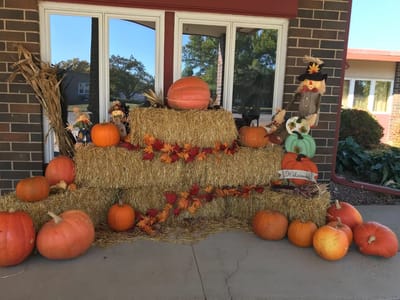 Fall decorations with pumpkins and hay bales at entrance