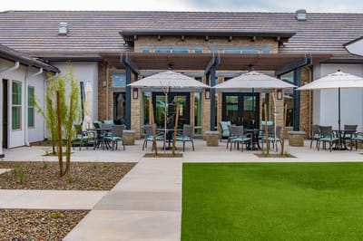 Outdoor seating area with umbrellas and green lawn