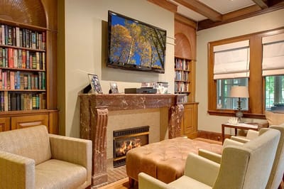 Cozy library area with comfortable seating and a fireplace
