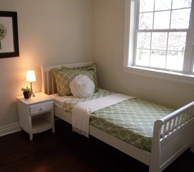 Cozy resident room with a single bed and lamp