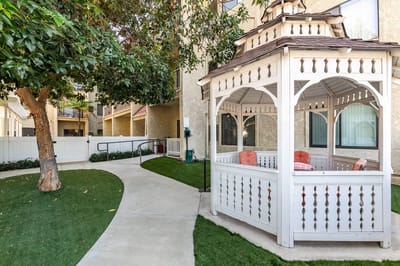 Outdoor gazebo with seating in a landscaped garden