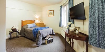 A cozy resident room with a bed and window