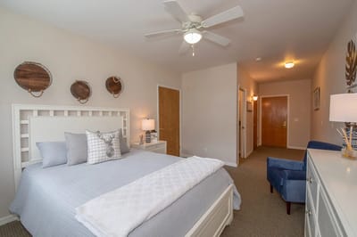 A well-decorated private resident room with a bed and furniture