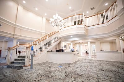 Bright and spacious lobby with staircase and chandelier