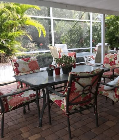 Outdoor seating area with floral cushions and greenery