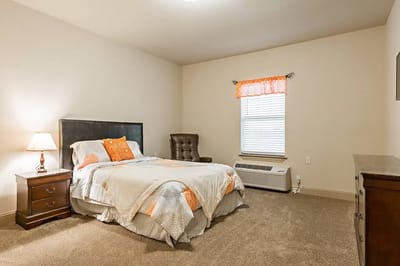 Bright and cozy private resident room with a bed and chair