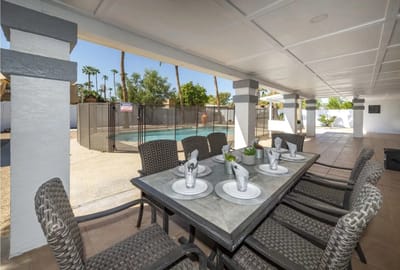Outdoor dining area with a table and swimming pool
