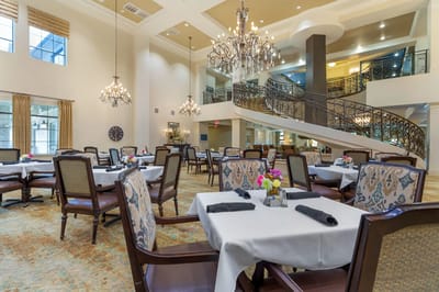 Elegant dining room with chandeliers and tables set for meals