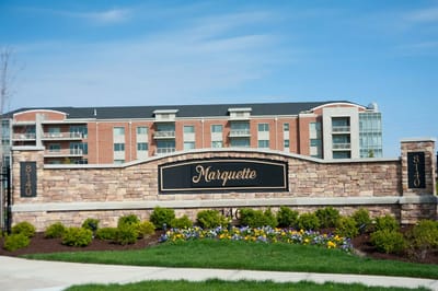 Exterior sign of the Marquette facility with colorful landscaping