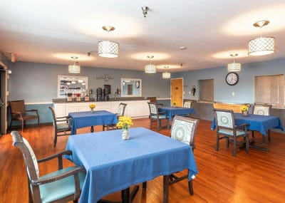 Bright dining area with blue tables and flowers