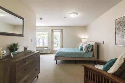 Bright interior of a resident room with a bed and furniture