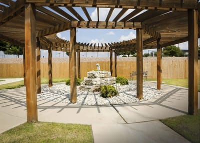 Outdoor seating area with wooden pergola and stone feature