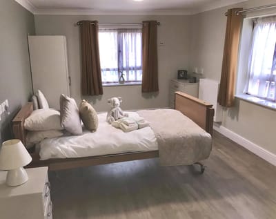 A well-furnished private resident room with bed and decor