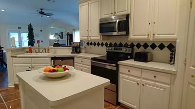 A well-lit kitchen with fruits on the counter