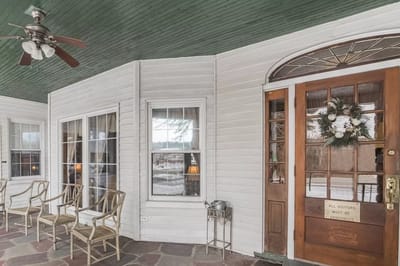 Covered porch with seating and front door entrance