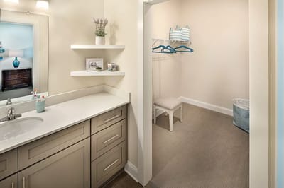 Bright bathroom area with storage and seating