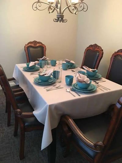 A beautifully set dining table with turquoise dishware