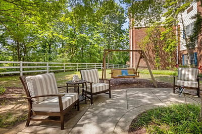 Outdoor seating area with chairs and swing