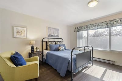 Well-furnished private resident room with a bed and seating area