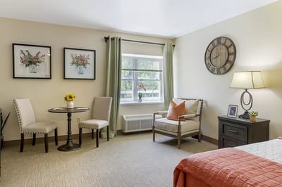 A well-furnished resident room with seating and decor