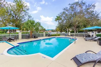 A serene outdoor pool area with lounge chairs and umbrellas