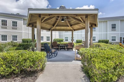 A covered outdoor seating area in a garden setting