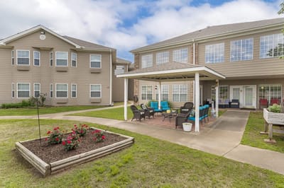 Outdoor seating area with colorful chairs and flower beds