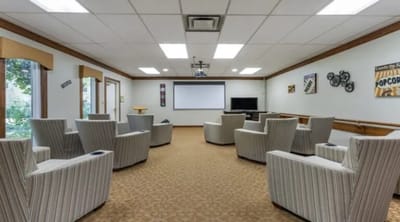 Bright common area with seating and a projector