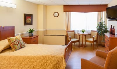 Cozy private resident room with a bed and seating area
