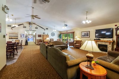 Common area with seating and fireplace in a senior living facility.