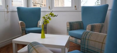 Bright common area with blue chairs and white table