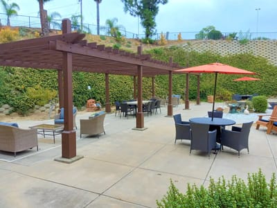 Outdoor seating area with shaded tables and chairs