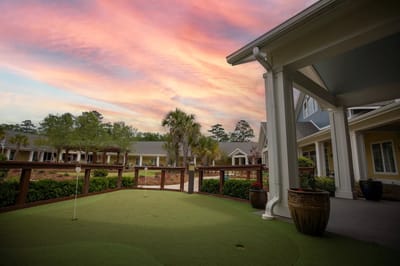 Outdoor putting green with a colorful sunset sky