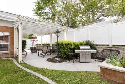 Outdoor seating area with grill and greenery