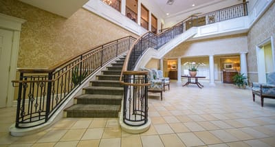 A well-lit interior lobby with a staircase and seating