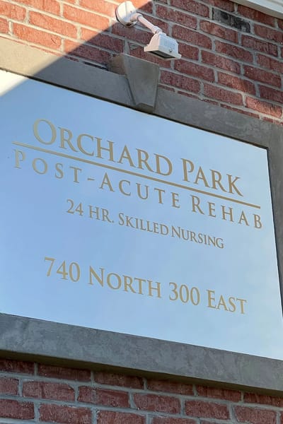 Sign of Orchard Park facility on brick wall