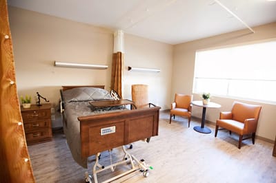 Comfortable resident room with bed and chairs