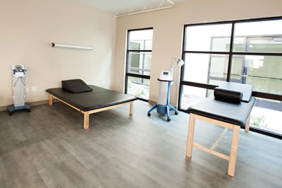 A bright therapy room with treatment tables