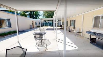 Outdoor seating area with tables and grill