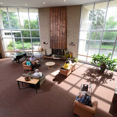 Residents socializing in a bright common area with large windows