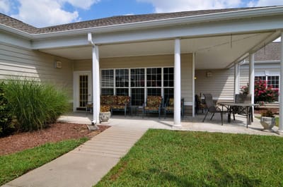 Outdoor seating area with flowering plants and grass