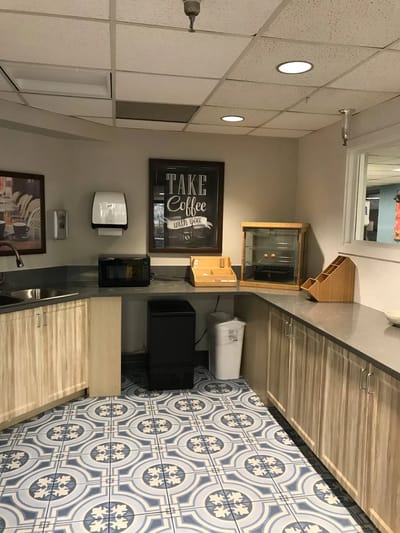 Bright kitchenette area with coffee station and decorative sign