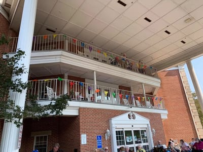 Exterior view of the Colonial Heights facility with residents on the balcony