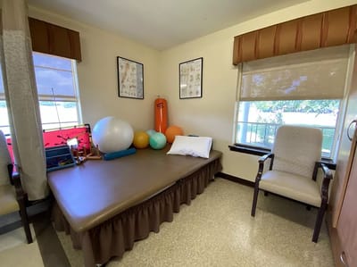 Physical therapy room with exercise equipment and seating