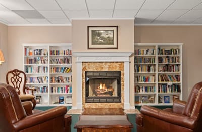 Cozy common area with fireplace and bookshelves